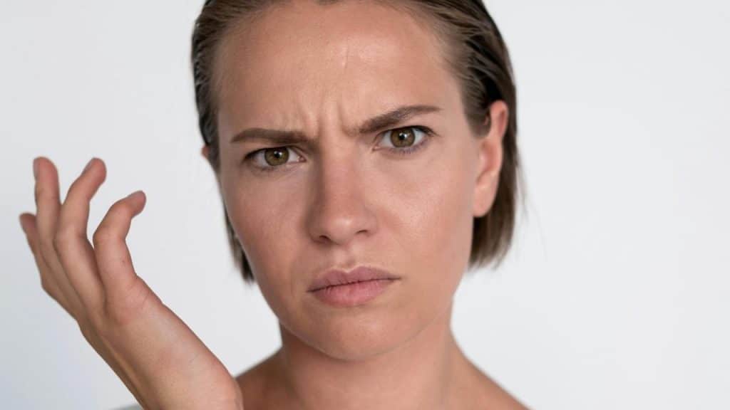 A confused woman looking forward with a puzzled expression.