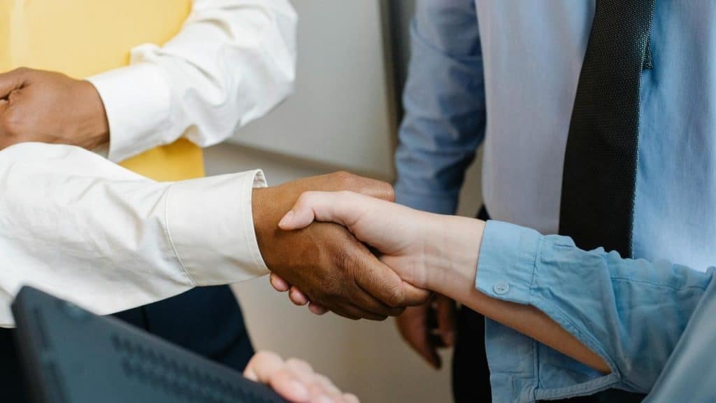 A handshake between two people in a business setting.
