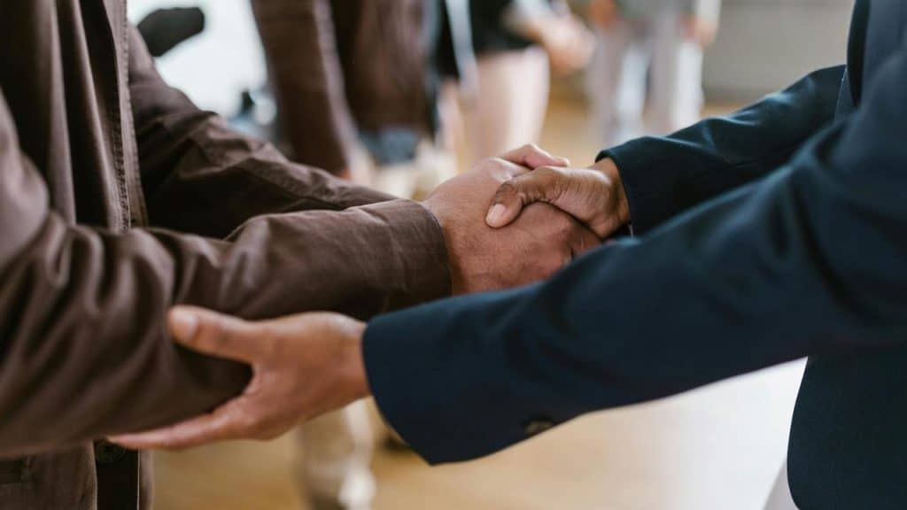 A close-up of two people shaking hands indoors.