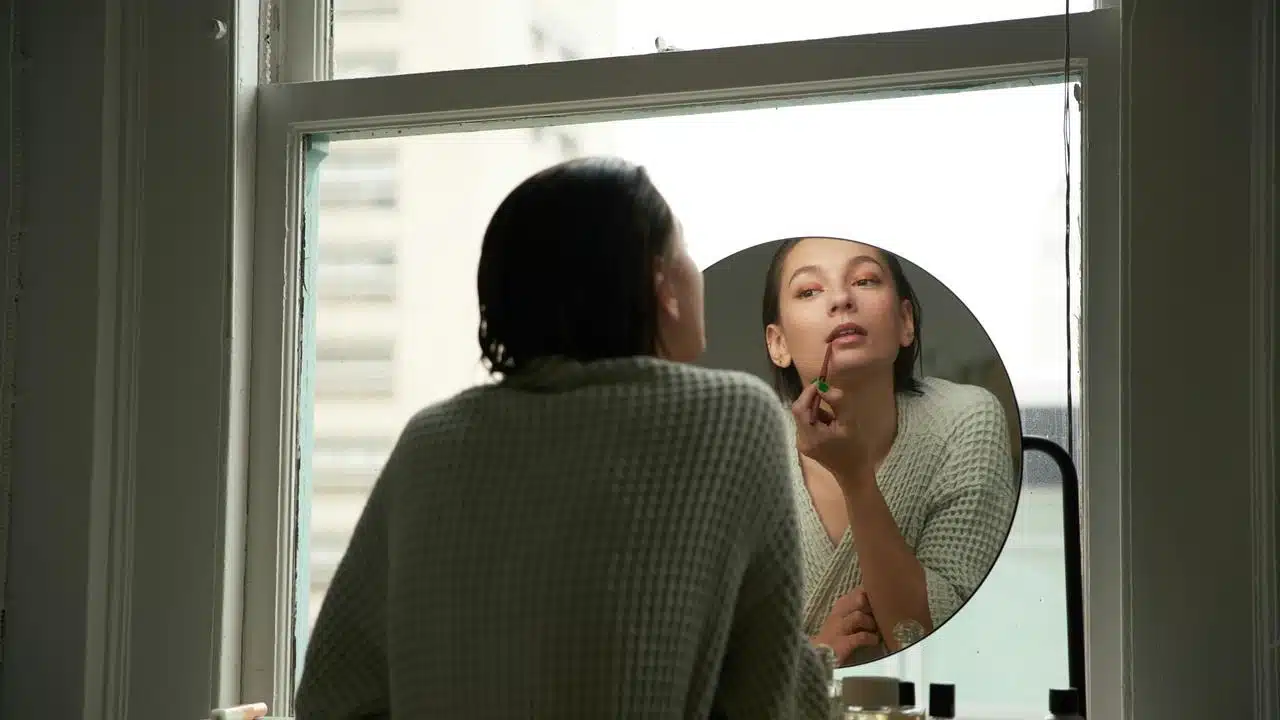 A woman applying lipstick