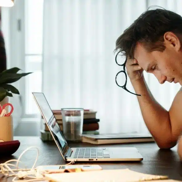 A person sits at a desk holding glasses