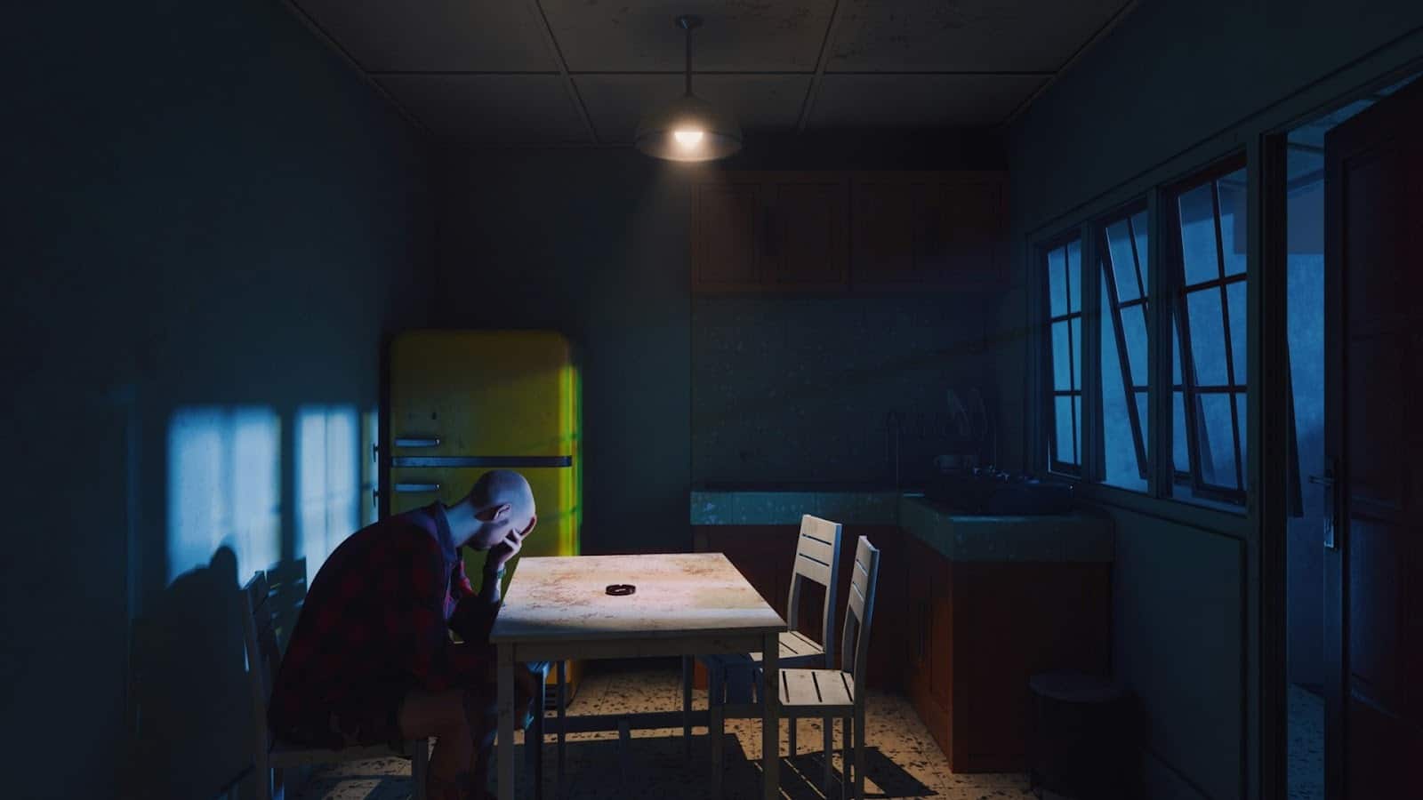 man sitting alone at kitchen table