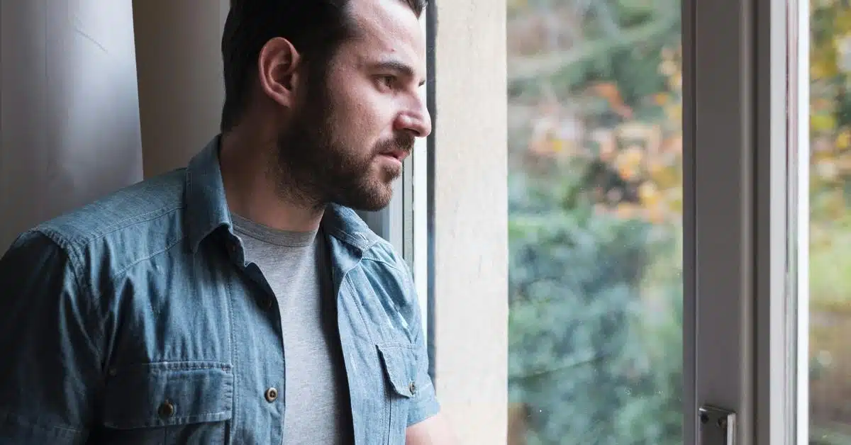 A man stands by a window