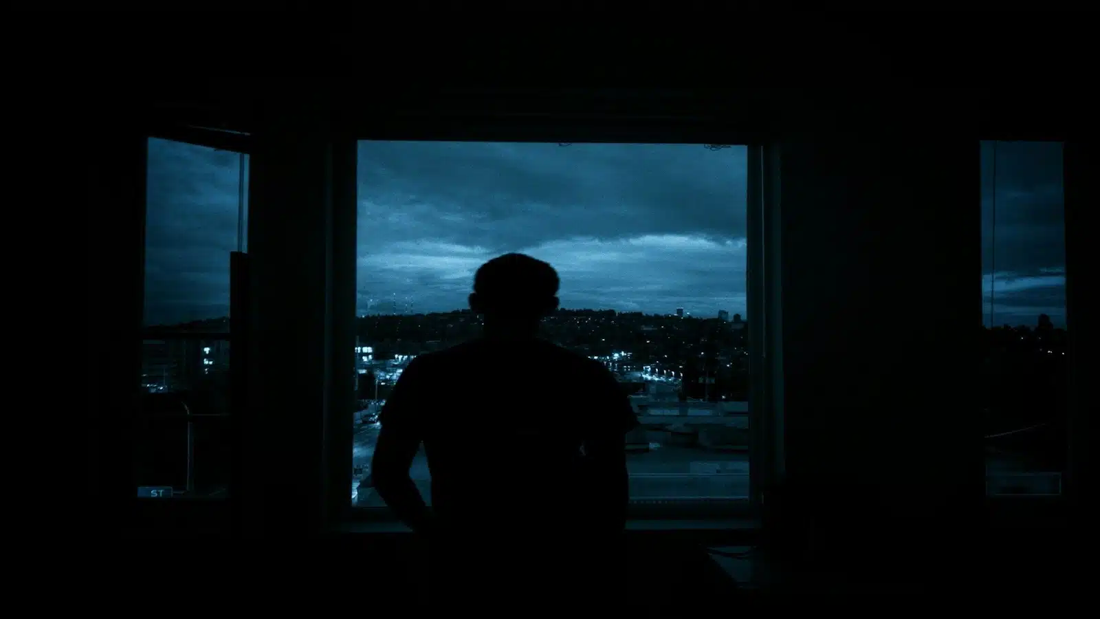 man sitting alone in dim room