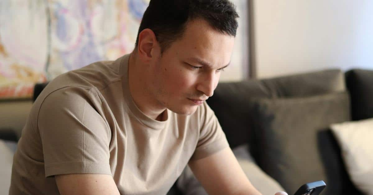 A man looking down at a smartphone