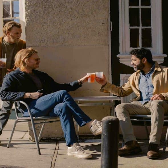 man sitting with friends at café