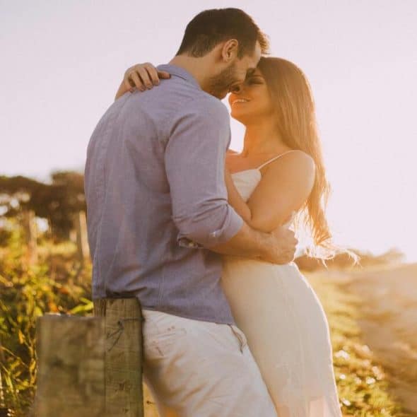 A couple about to kiss at sunset