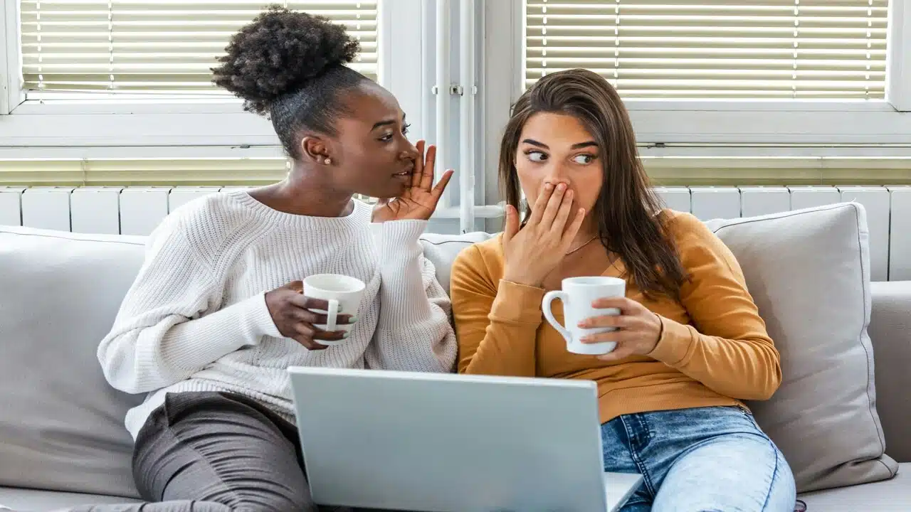 Two women gossiping by the couch