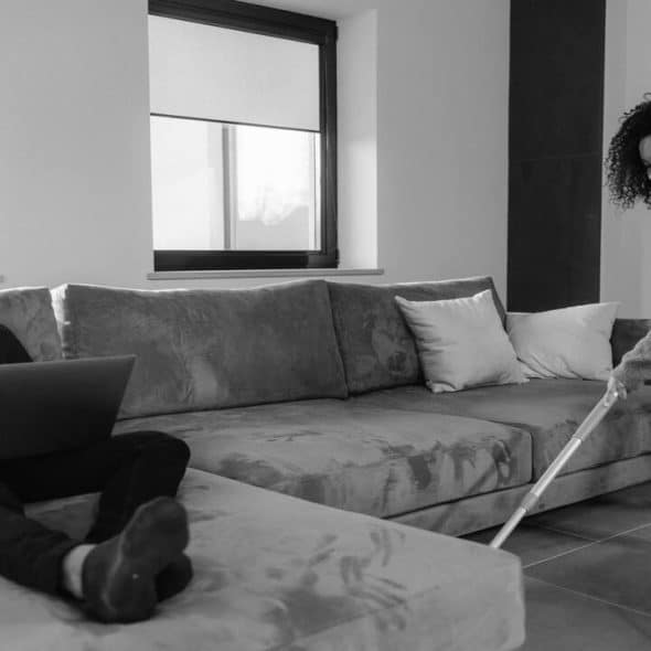 A woman cleans while her husband works
