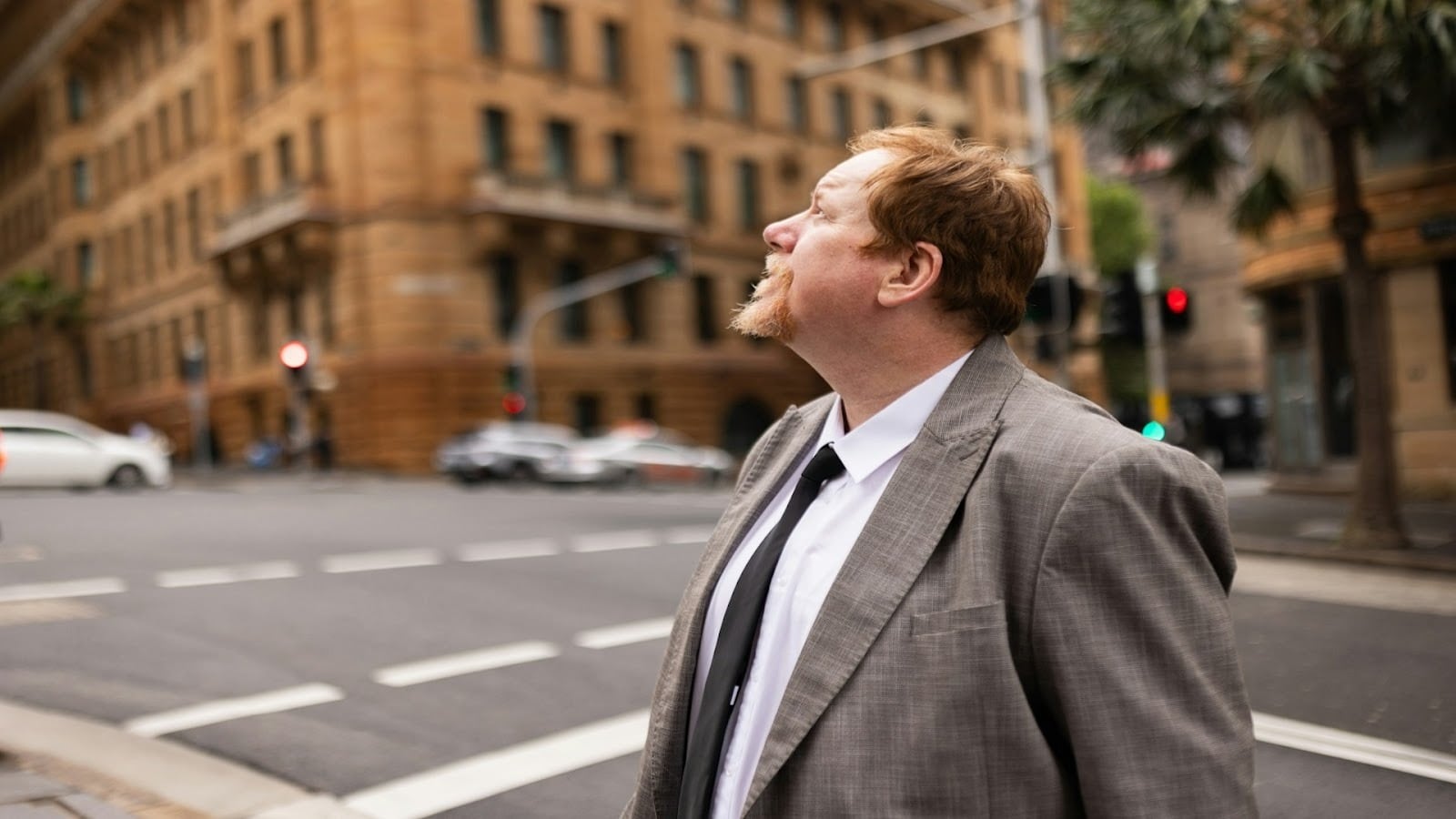 man standing thoughtfully in city