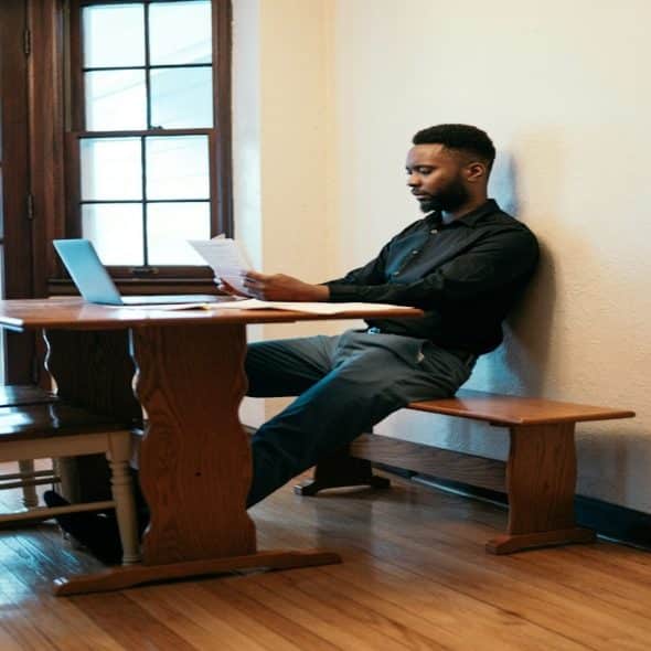 man sitting at desk reviewing finances