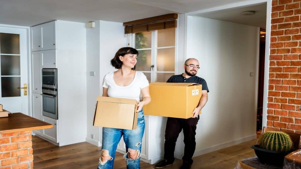 couple carrying boxes into apartment