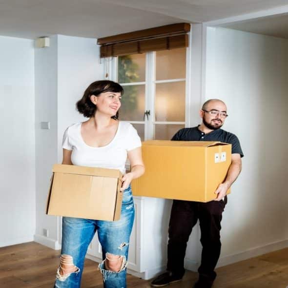 couple carrying boxes into apartment
