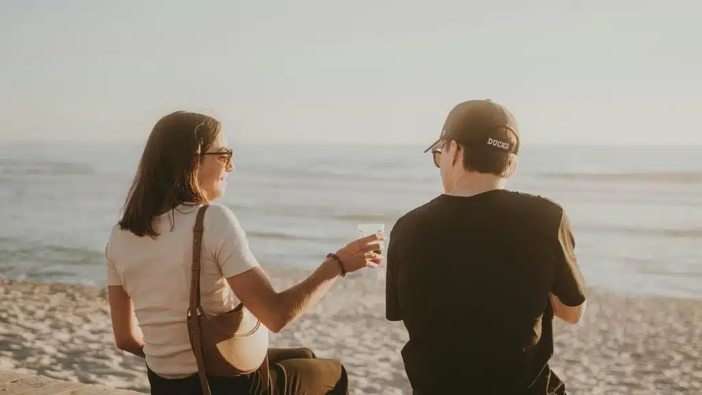 A couple sitting on a beach ledge