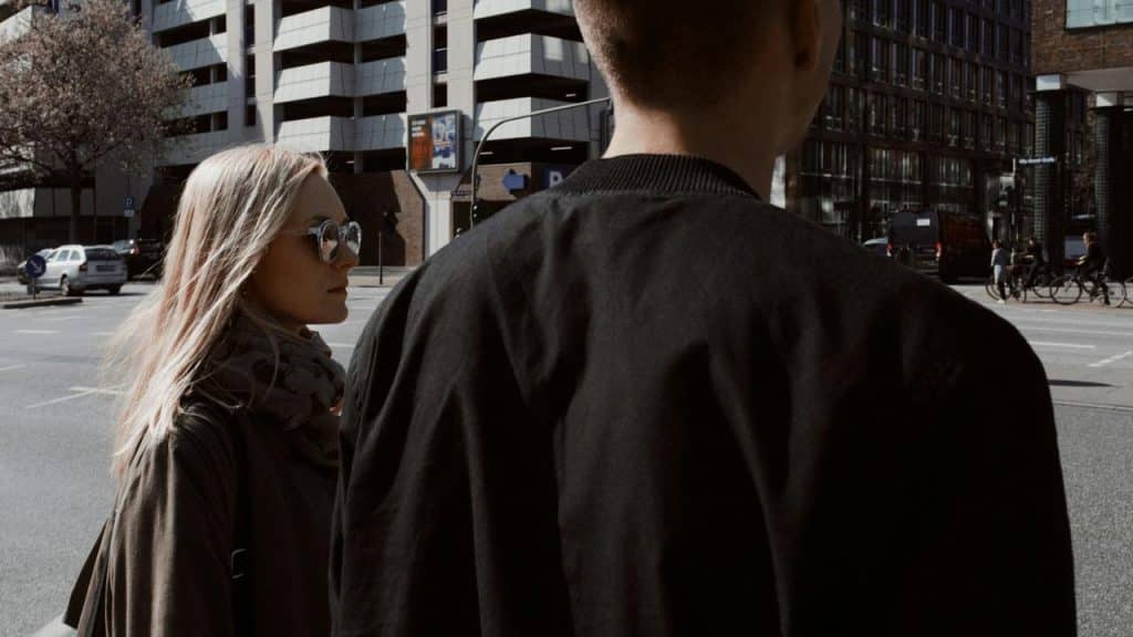 A couple standing at a city street crossing