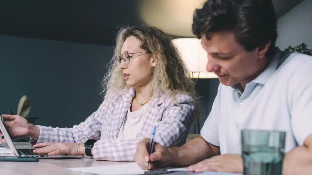 A woman showing something on a laptop