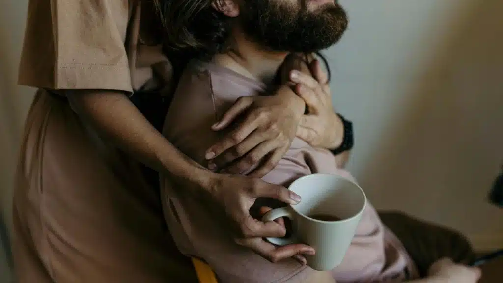 A person hugging their partner from behind