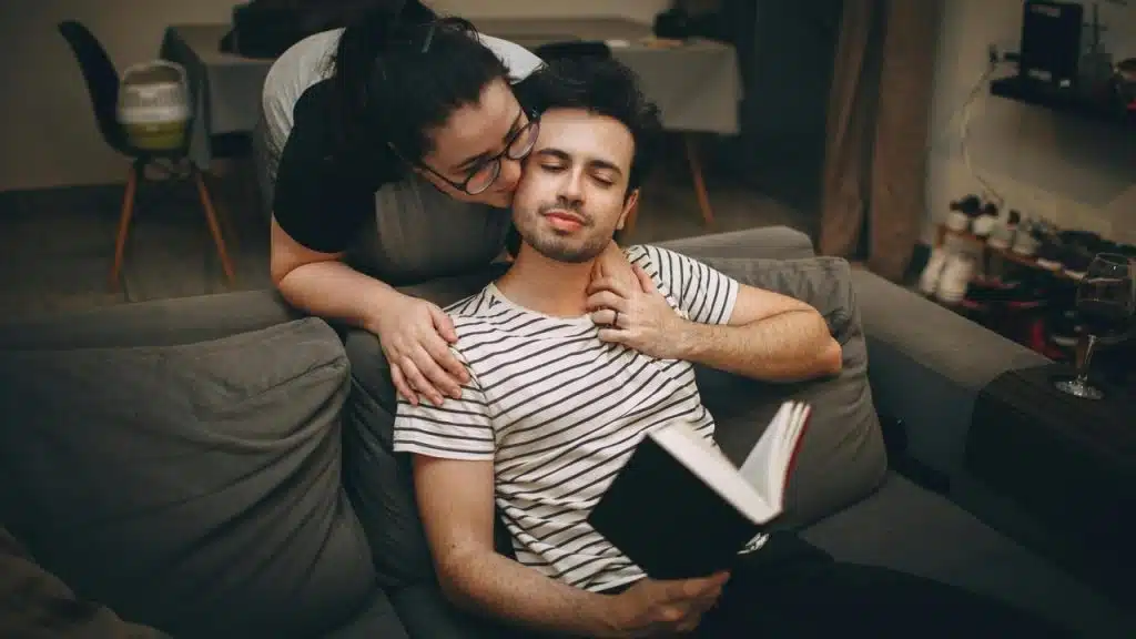 A woman kissing a man on the cheek 