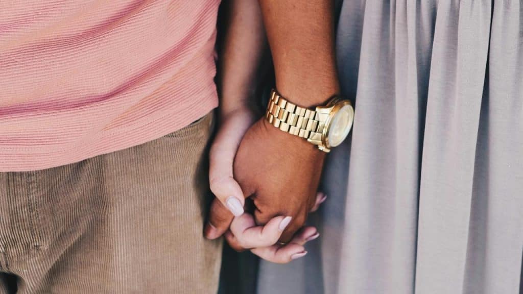 A close-up of two people holding hands