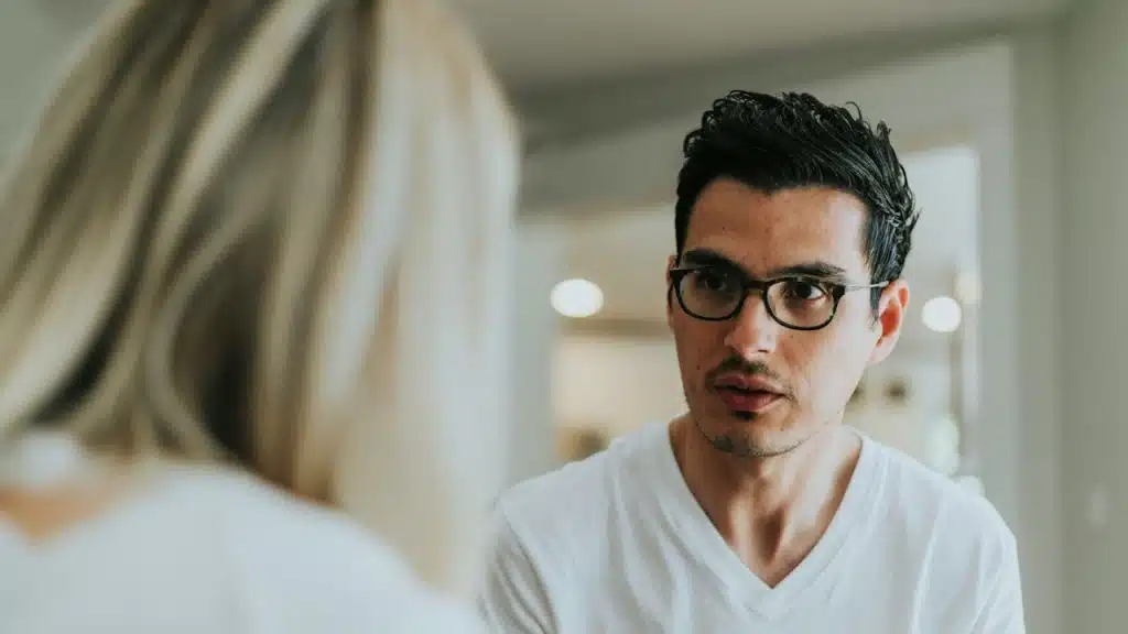 A man looking at a woman sitting next to him.
