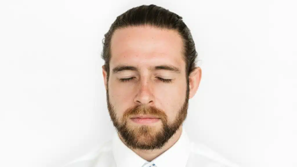 A close-up of a man with his eyes closed.