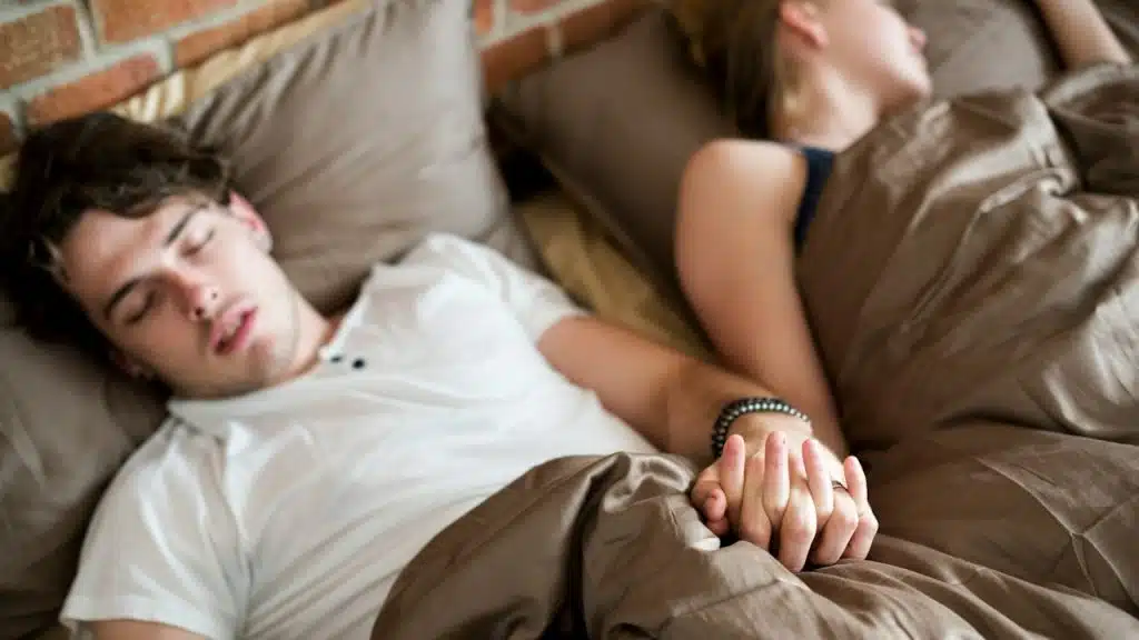A couple sleeping on a bed together.