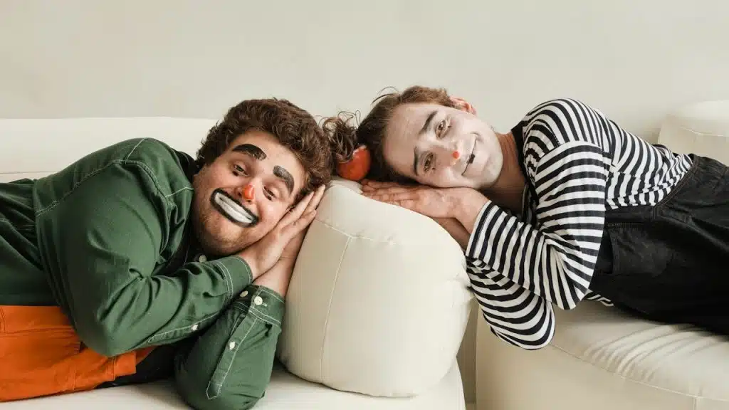 A couple of people lying on top of a white couch.