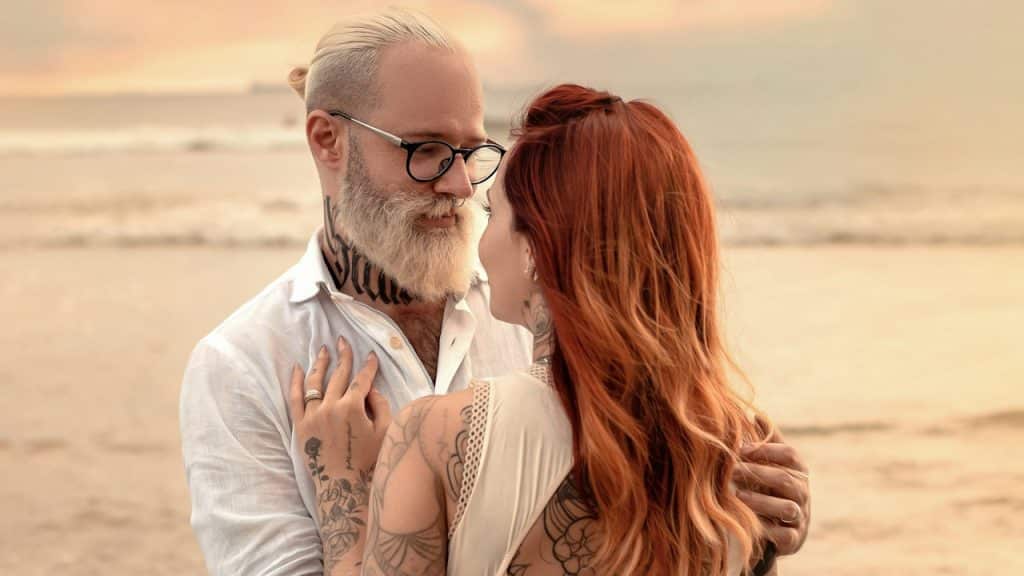 A man and woman hugging on a beach.
