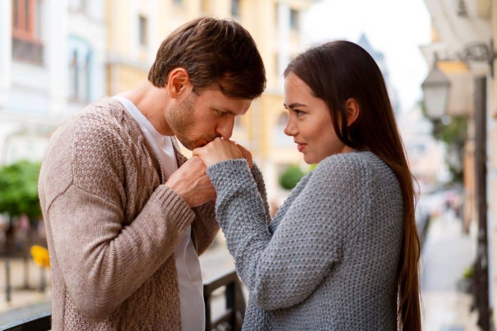 A man kissing woman’s hand