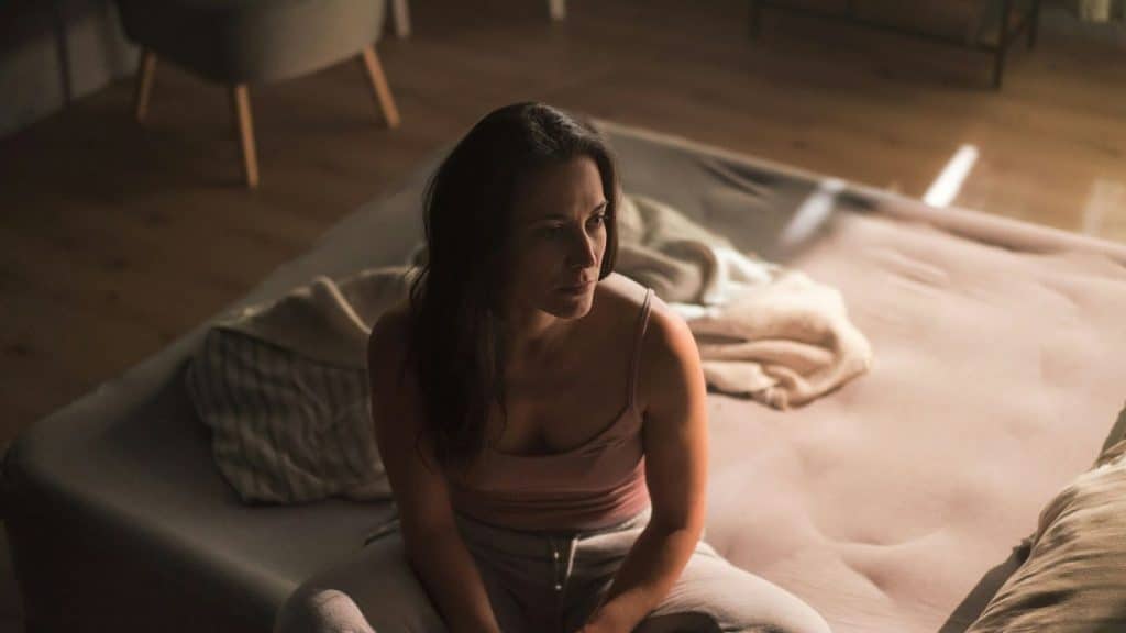 Woman alone and sitting at the bed