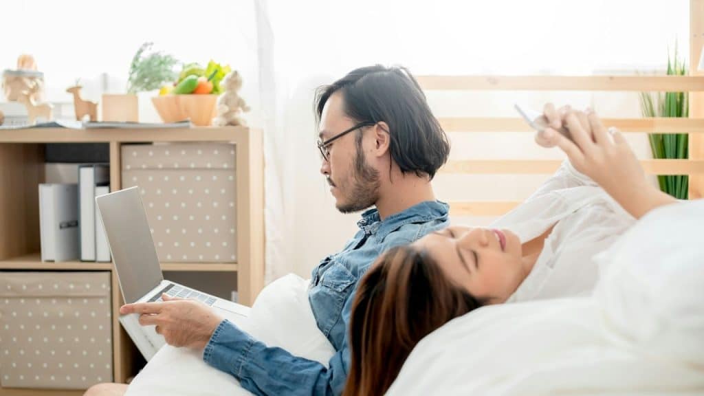 A man and woman busy with their gadgets