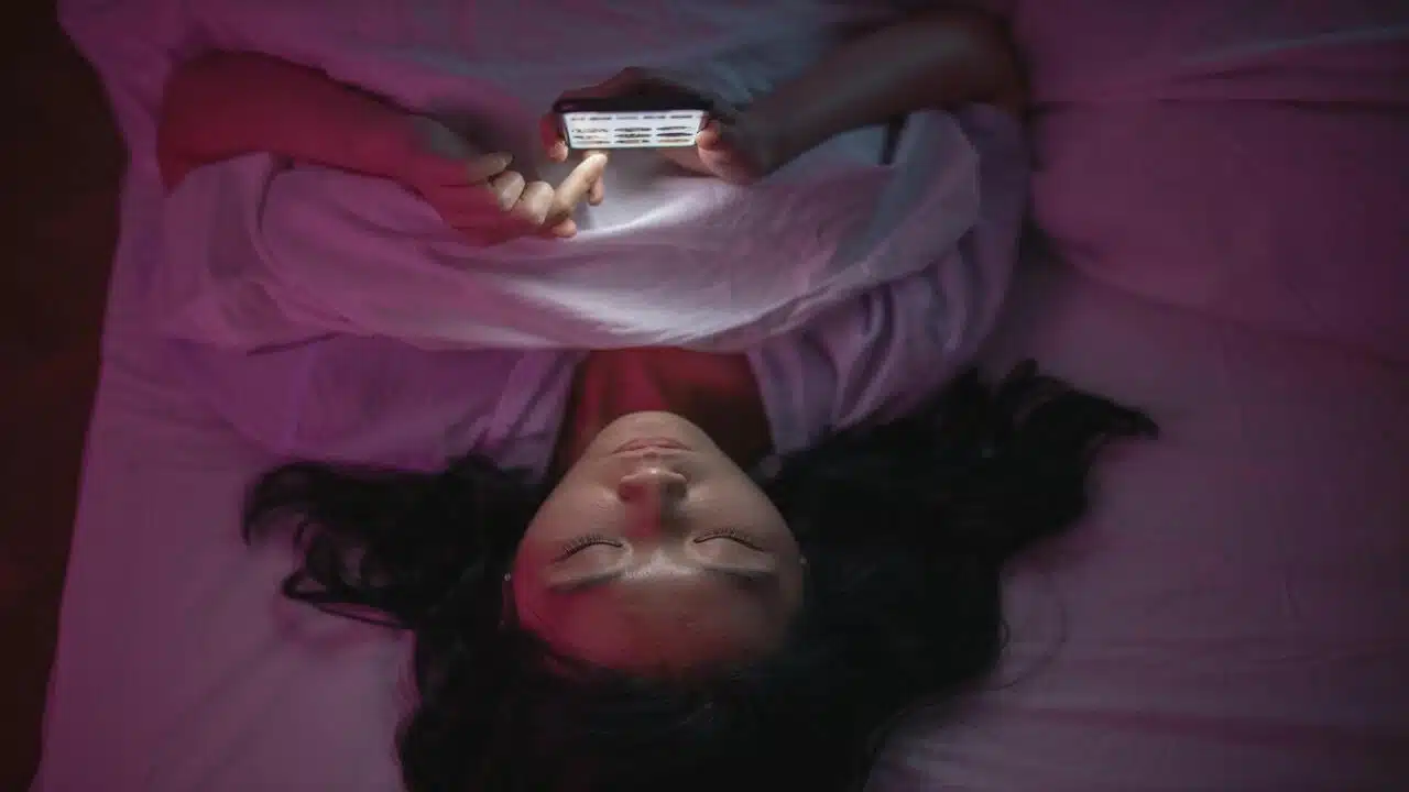 A woman texting in bed