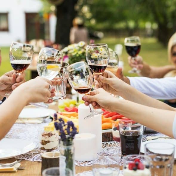 A group of people having a toast while sitting at a dinner table.