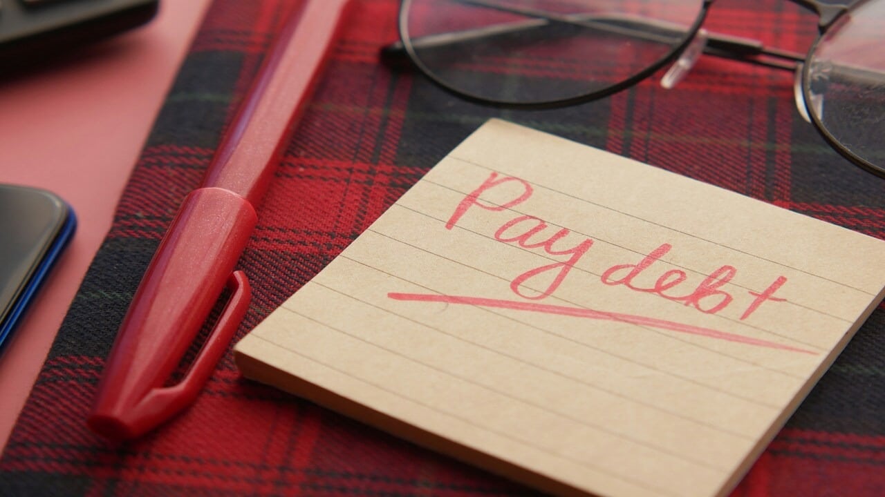 A handwritten note saying “pay debt”