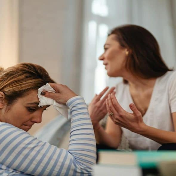 A woman looking sad while her friend talks