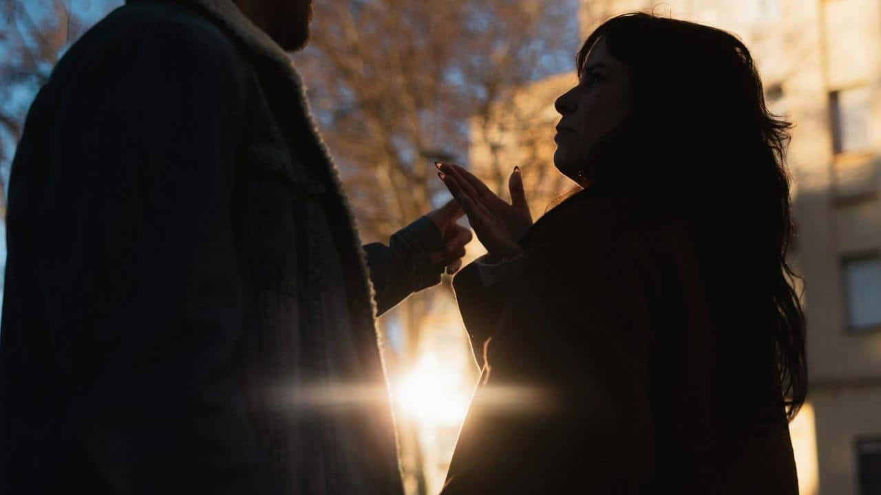 A silhouetted couple arguing outdoors
