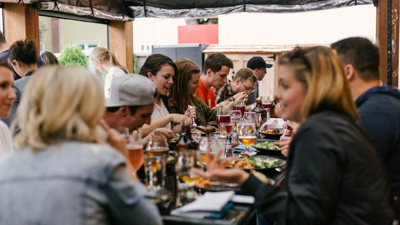 A group of people sitting at a table having dinner.