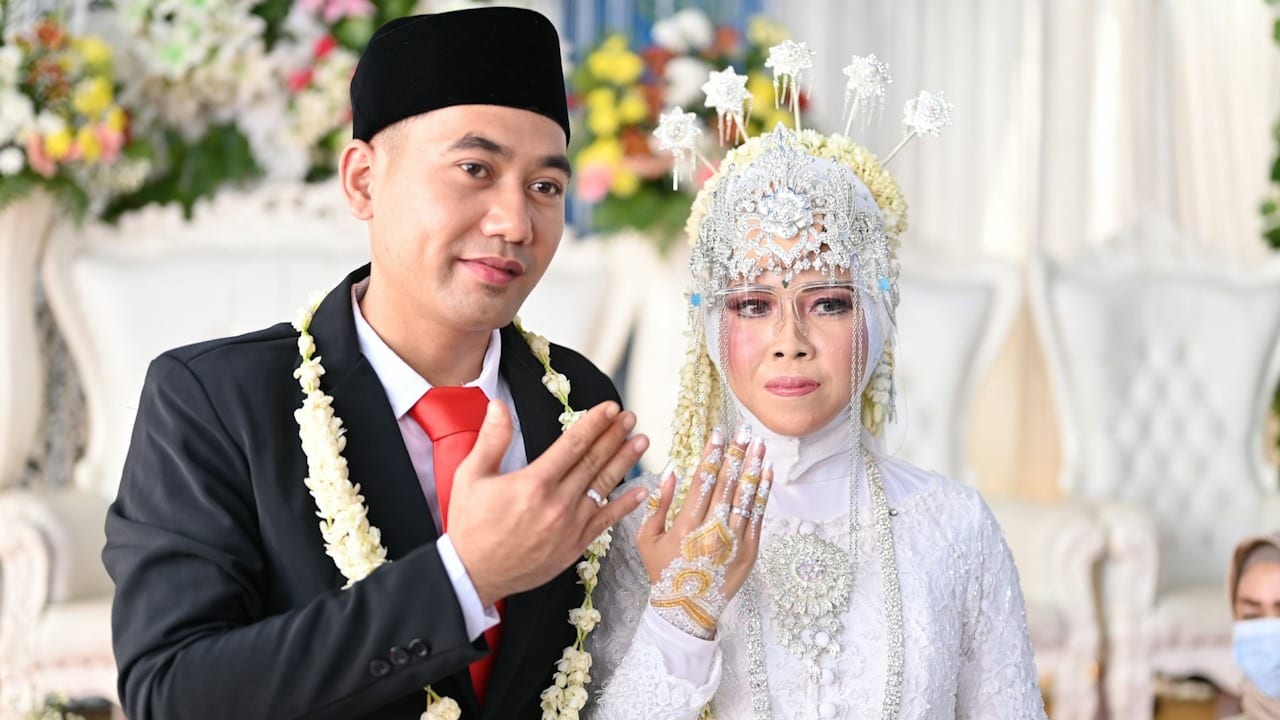 A man and a woman dressed in traditional Thai garb.