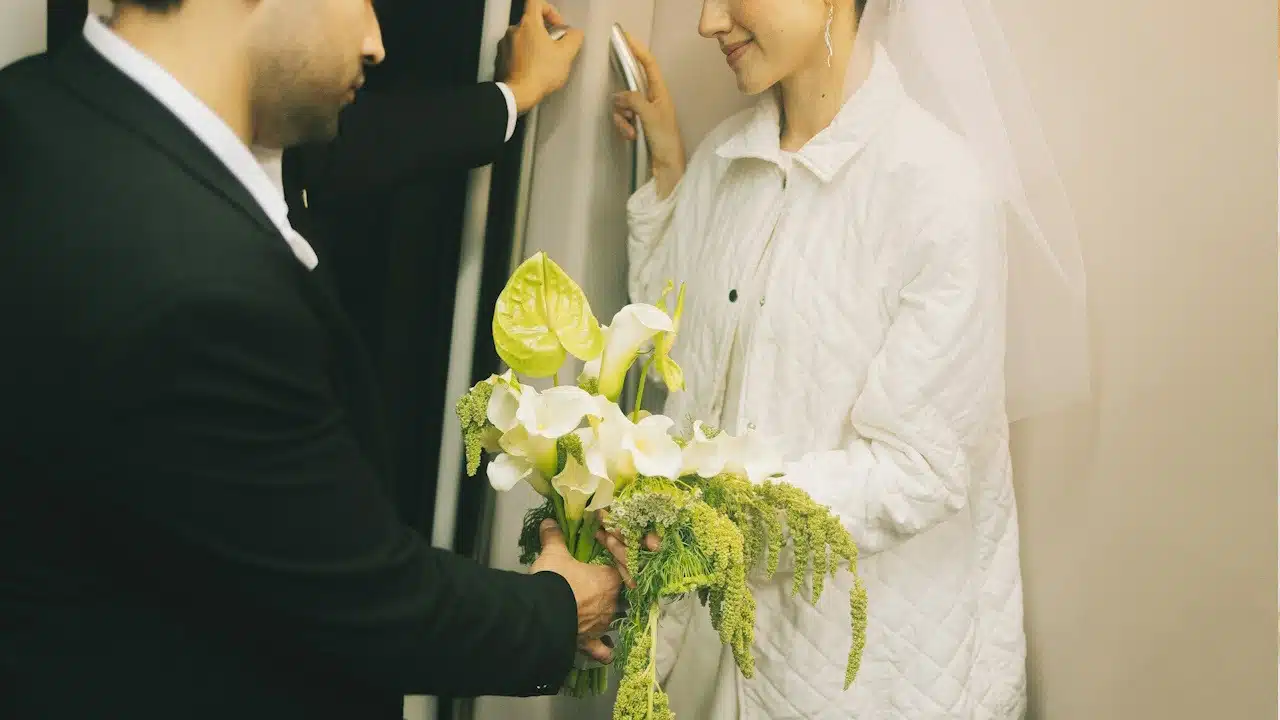 A man in a suit gives a woman a bouquet.