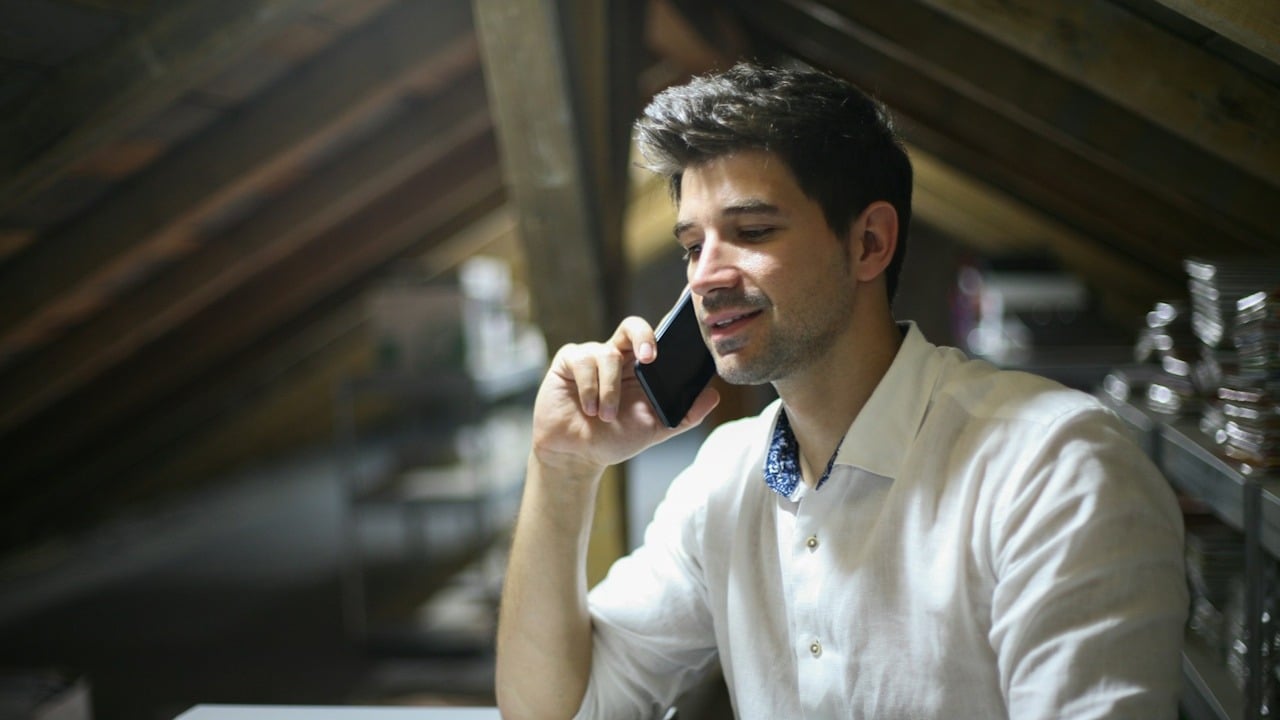 A man sitting alone is calling on phone.