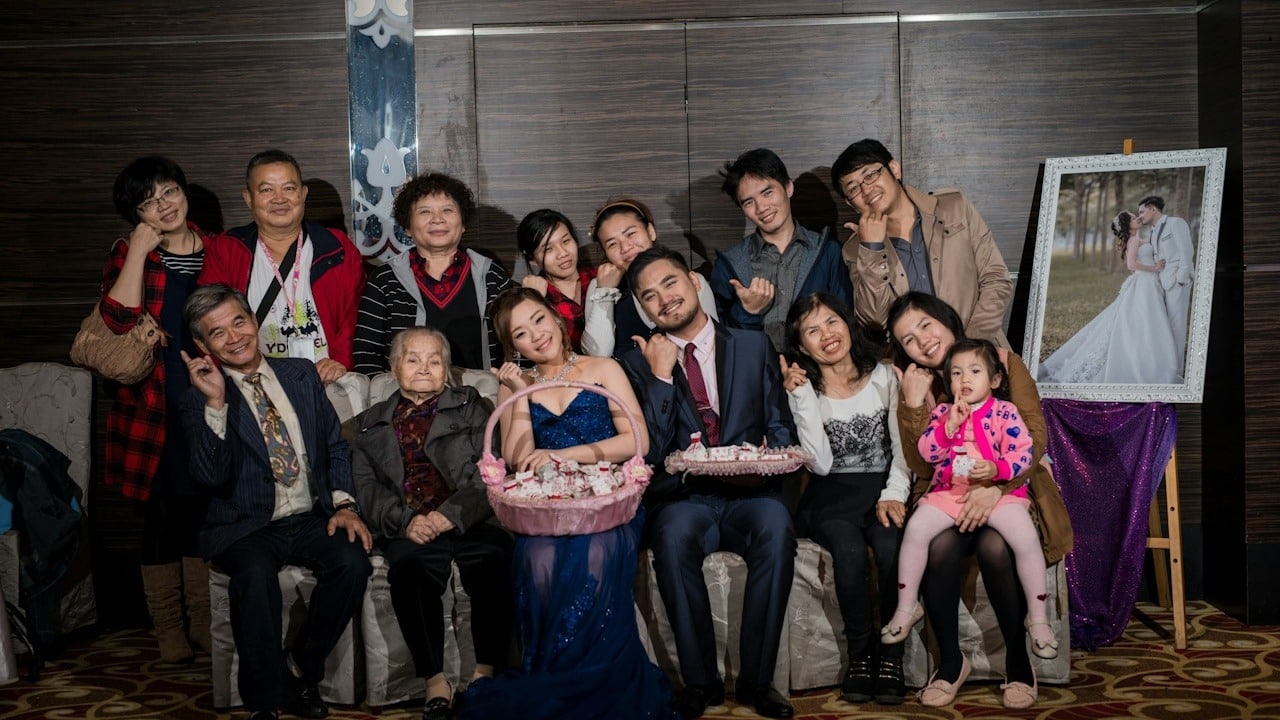 A couple sitting with their extended families on their marriage.