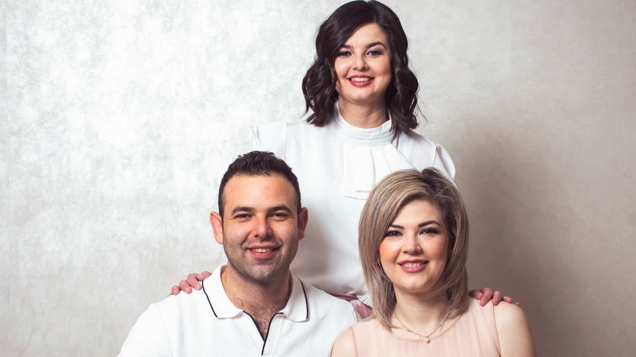 A group of three people posing for a picture.