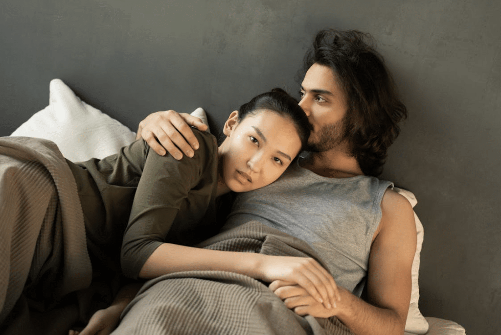 Woman Unhappily Lying on a Man's Chest in Bed