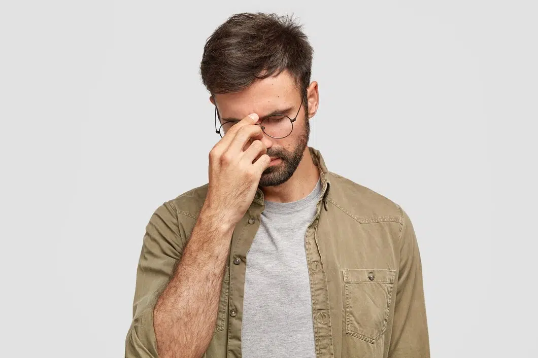 Man with glasses frowning