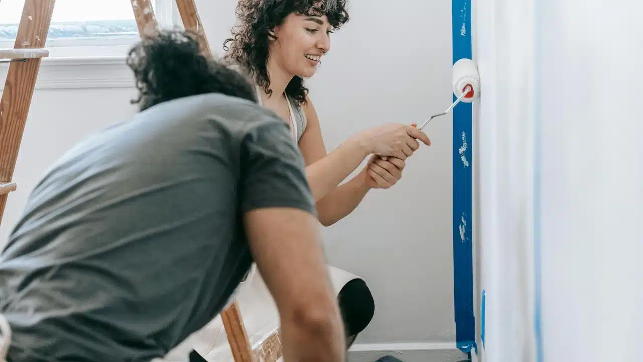A couple painting a wall together