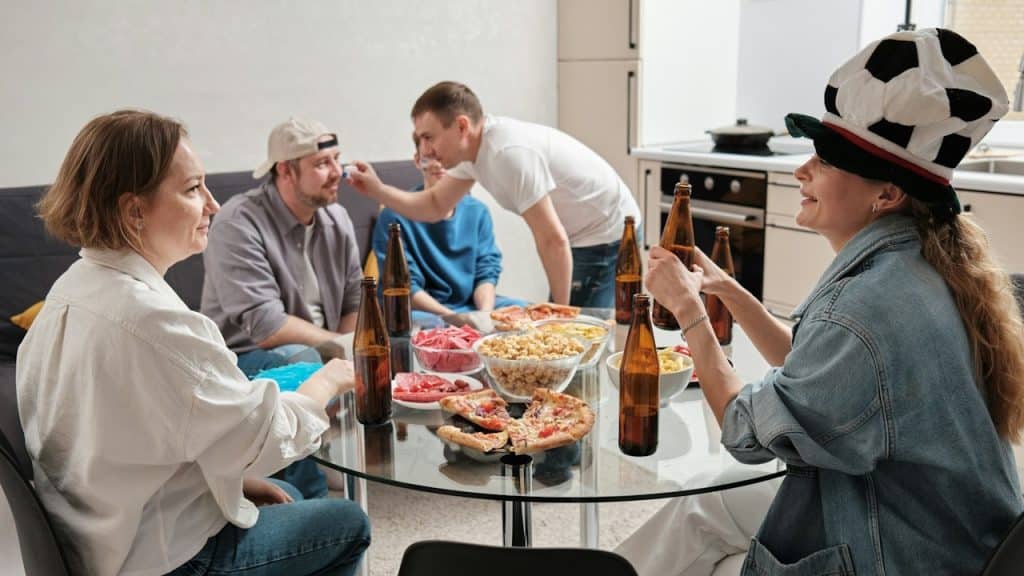 A group of people sitting around a table eating pizza.