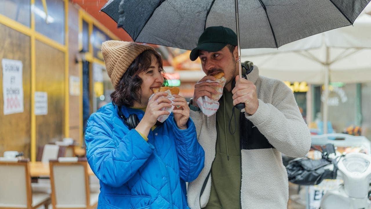 A couple standing under an umbrella in the rain