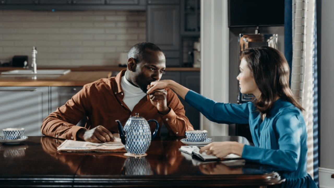 A man kissing his wife’s hand
