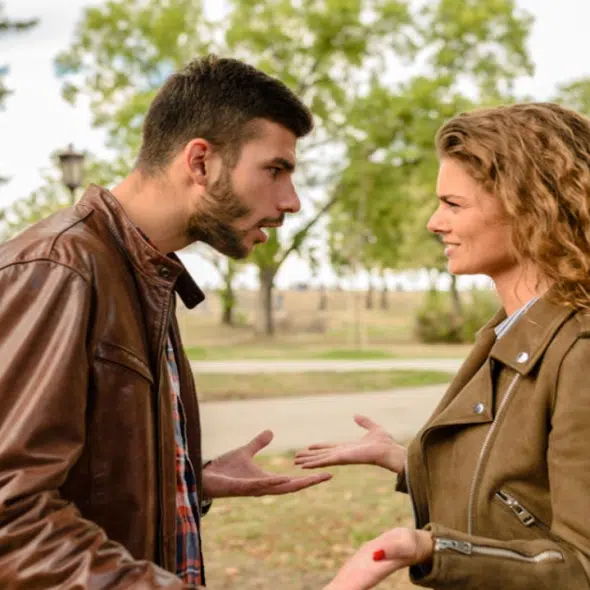 A couple fighting outdoors