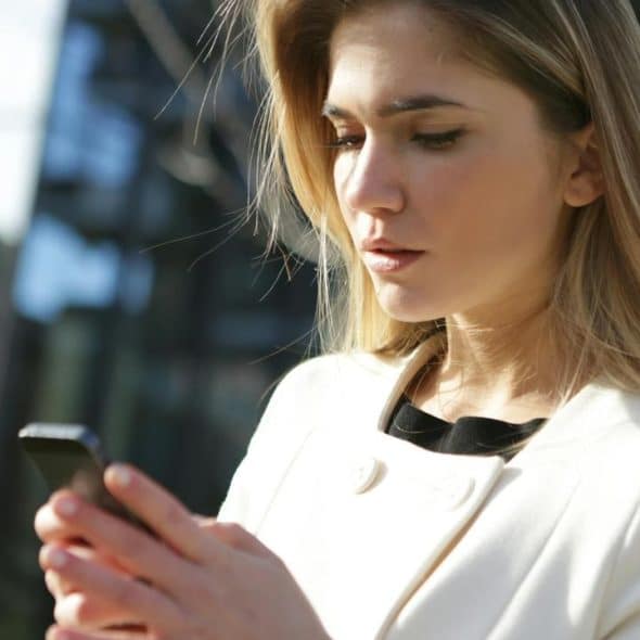 A woman outdoors looking at her phone